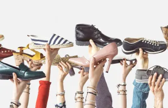 variety of hands holding up different shoes