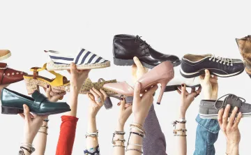 variety of hands holding up different shoes