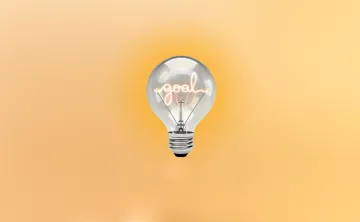 Light blub with the word "goal" in the middle of it, on a muted yellow background.